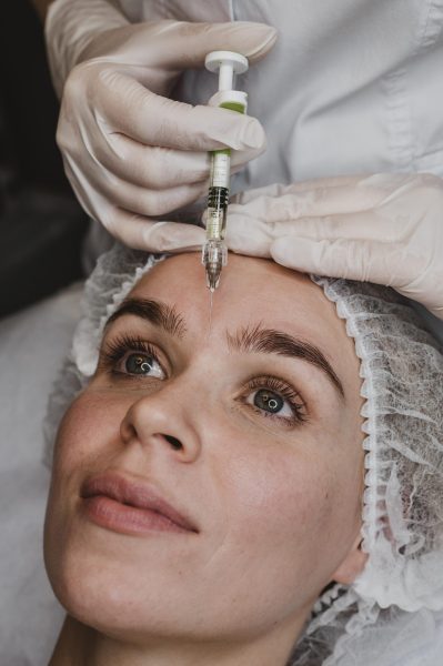 mujer recibiendo una inyeccion de belleza facial en el centro de bienestar